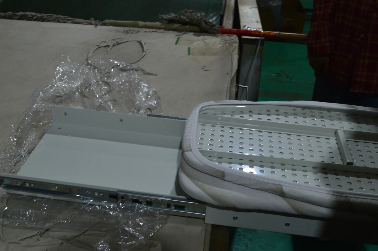 Guías de extracción junto a un conjunto de tabla de planchar plegada sobre un banco de trabajo